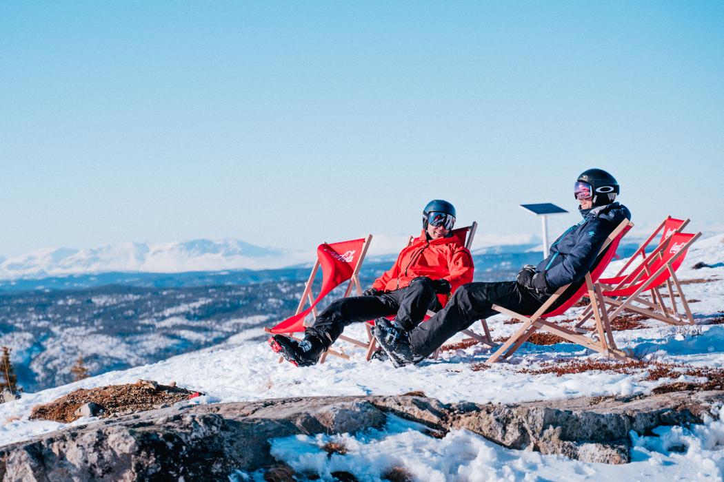 To stk som koser seg i solen på toppen av alpinbakken