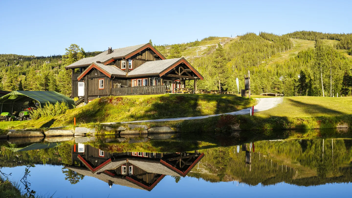 et hus på høyden ved en innsjø