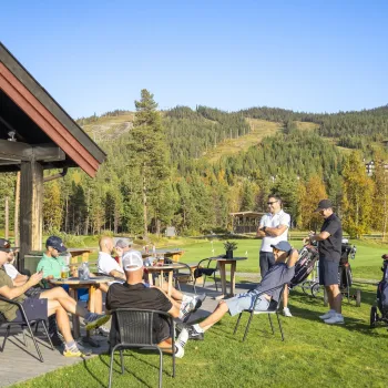 Gjester nyter solen utenfor Nesfjellet Golf Kafé