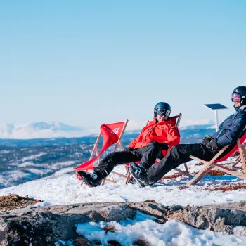 To stk som koser seg i solen på toppen av alpinbakken