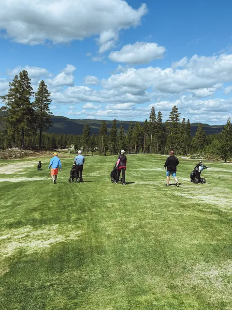 En gruppe mennesker som går på en golfbane