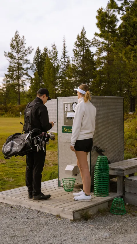 To personer ved ballautomat Nesfjellet Golf