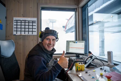 en person som sitter ved et skrivebord med tommelen opp