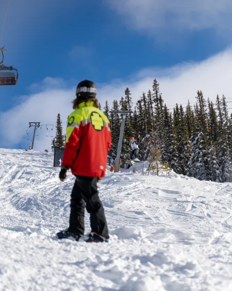 en person i skidress på et snødekt fjell
